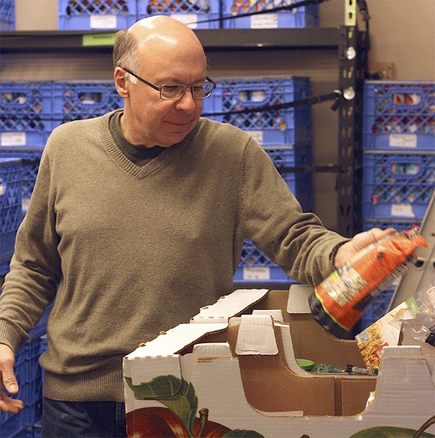 Food bank volunteer Brian Jonas packages delivery boxes for the Groceries 2 Go program.