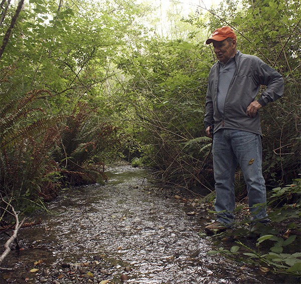 Longtime Plateau resident Wally Pereyra stands in Zaccuse Creek in late July. Pereyra hopes the kokanee will one day spawn in this stream