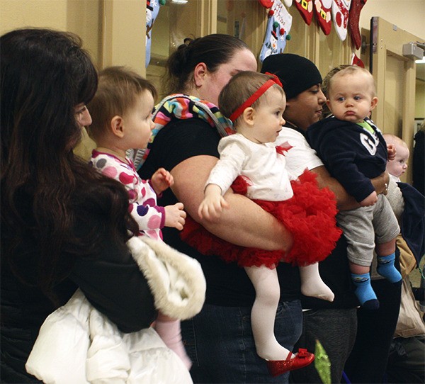 Infants from Evergreen Academy Preschool in Issaquah standby as their peers sing classic holiday carols to residents at Spiritwood at Pine Lake