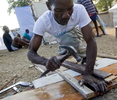 A displaced Haitian man builds a makeshift shelter at Port-au-Prince's golf course where many have set up temporary homes. Thanks to a tent drive organized by Issaquah's Susan Sullivan