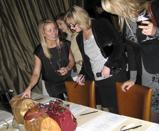 Women from the Sips and Tips social club discuss purses at an auction.