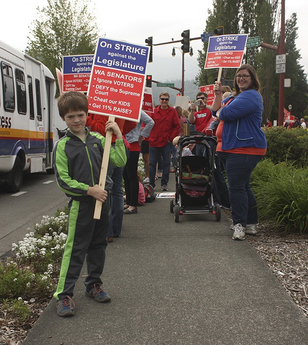 Jonas Moore (foreground) joined his father Joshua as well as dozens of Issaquah teachers and their supporters to picket Front Street and Northwest Gilman Boulevard Tuesday morning. The Issaquah Education Association staged a walkout to protest the state legislature and the lack of progress on funding for basic education.