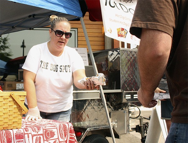 Sandra Collins hands a hot dog to a customer at Sammamish Days Aug. 22. Collins and her husband