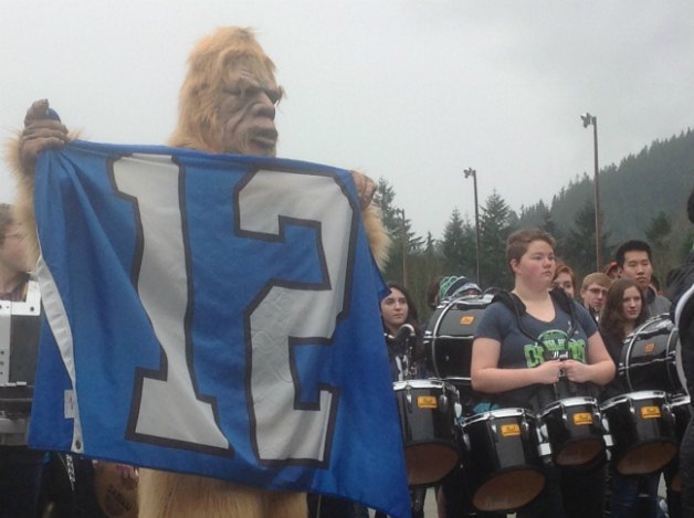 Sasquatch waves the Seahawks' 12th Man flag in front of the Issaquah Eagles band at an Issaquah High School Blue Friday rally.