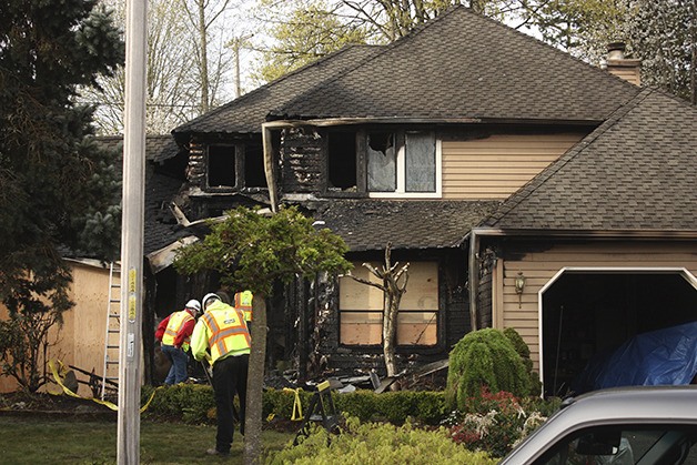 Contractors work on a Sammamish home four hours after firefighters put out a blaze. The home was unoccupied at the time of the fire.