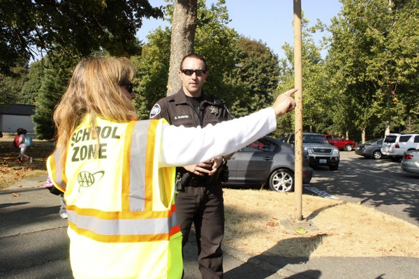 Sammamish police officer Ryan Olmsted speaks with Margaret Mead Elementary crossing guard Janet Vestal. She was concerned about parents crossing the street with their children and not using the crosswalk.