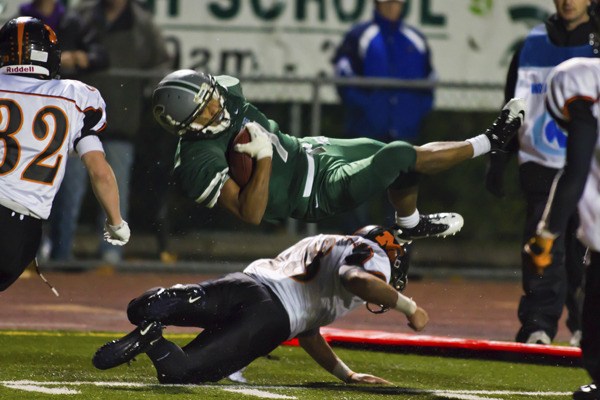 Skyline's Damien Greene makes a diving catch at the 1-yard line Friday flying over Monroe defender Troy James. The Spartans advanced through the state-qualifying round to face Mead in Spokane this Saturday.