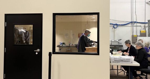 Election workers open mail in a new secure room at Thurston County’s elections office. The county invested in a separate room to open mail after it was sent an envelope containing fentanyl last year. (Laurel Demkovich/Washington State Standard)